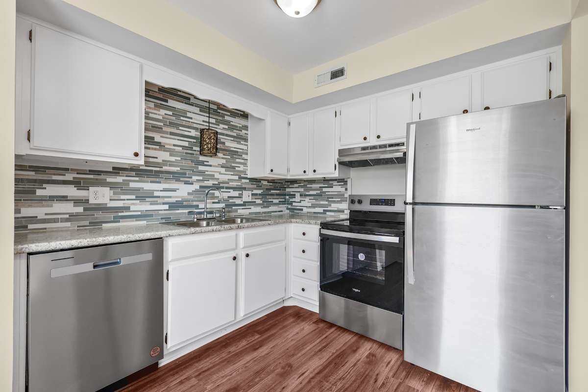Check out this updated kitchen with tile backsplace and newer stainless still appliances.