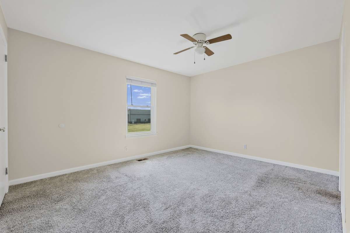 Comfortable bedroom with ceiling fan and blinds already in place.