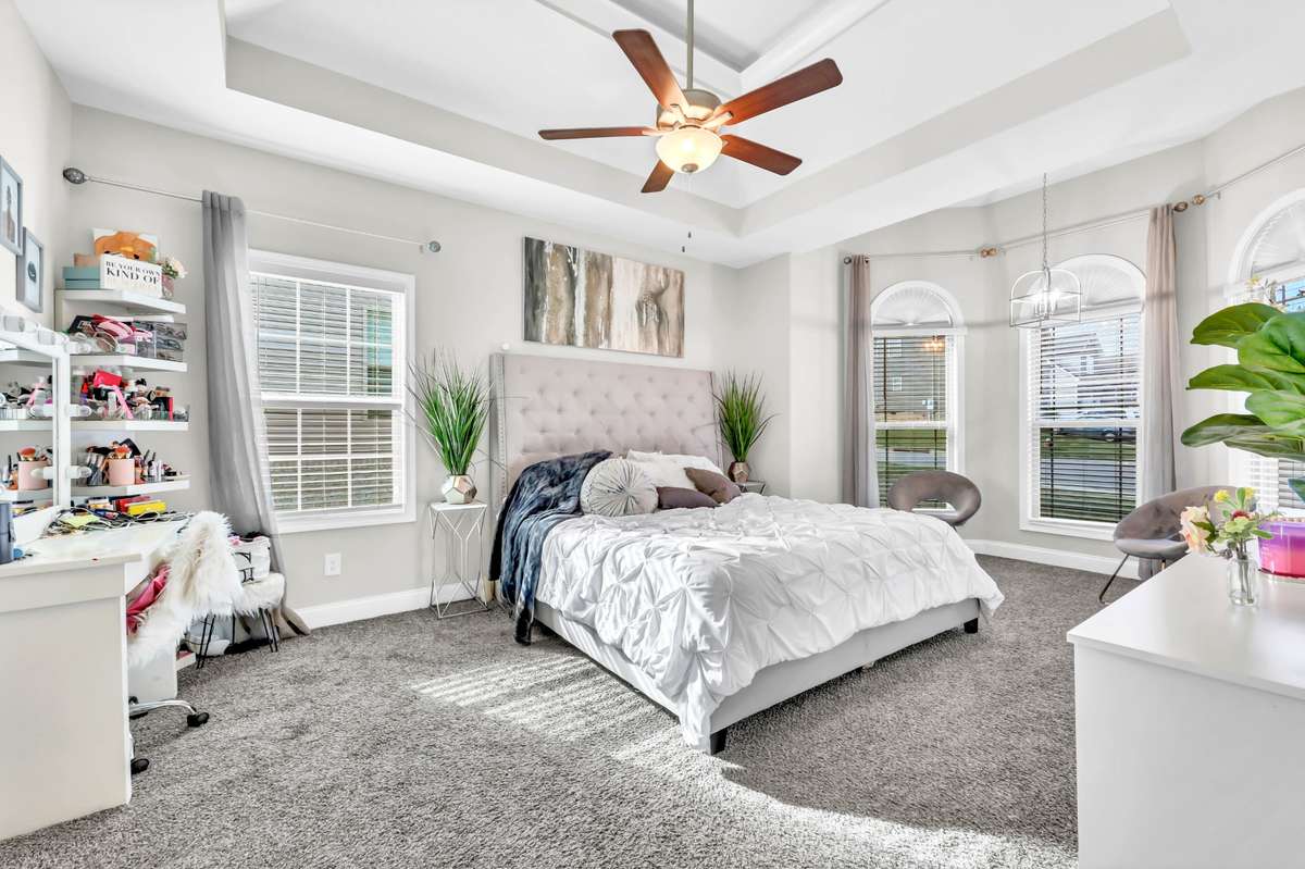 Downstairs primary bedroom with double tray ceilings and sitting area.