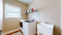 Main level laundry with utility sink.