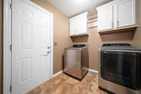 Laundry area offers easy access to the garage, complete with newer washer and dryer staying with the home.