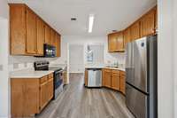 The kitchen offers stainless steel appliances including refrigerator