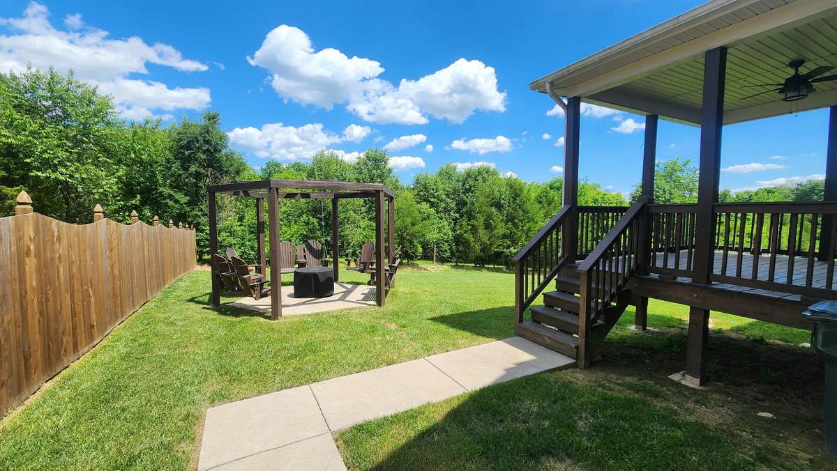 Spacious yard with lots of room to run and play for dogs and kids!  Enjoy grilling or evening fires for your entertaining and relaxing needs in this back yard that backs up to woods.