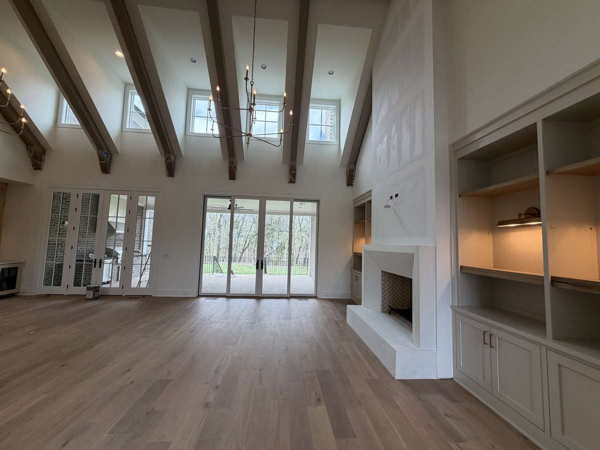 Vaulted Great Room with wood burning fireplace. *this home is under construction.  Photo taken: 4/6/26