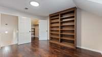 Upper level bonus room has abundant storage options with built in shelving and walk in closet with shelving.