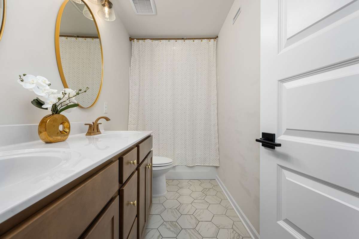 Dual vanities in the upstairs bathroom with tub/shower combo.