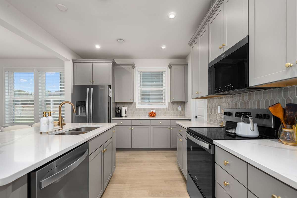 Quartz counters, tiled backsplash, Whirlpool stainless appliances, kitchen island and walk-in pantry
