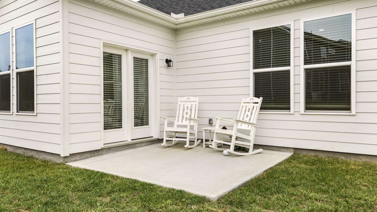 Backyard includes patio for relaxing just off sunroom.