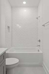 Indulge in luxury with this beautiful tub, elegantly surrounded by pristine white tiles that elevate the design of your bathroom.