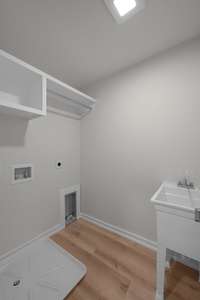 The laundry room is centrally located and has a large work sink for laundry needs or bathing Fido!