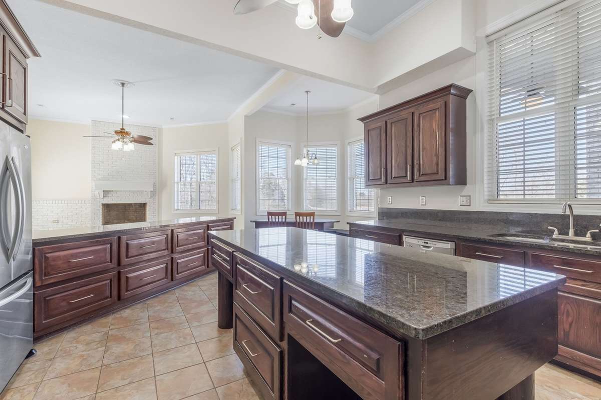 This view of the kitchen highlights the sheer size of the room. There is a glimpse of the breakfast table which overlooks the view of the back acreage, you will also see the fireplace in the distance which is located in the keeping room..
