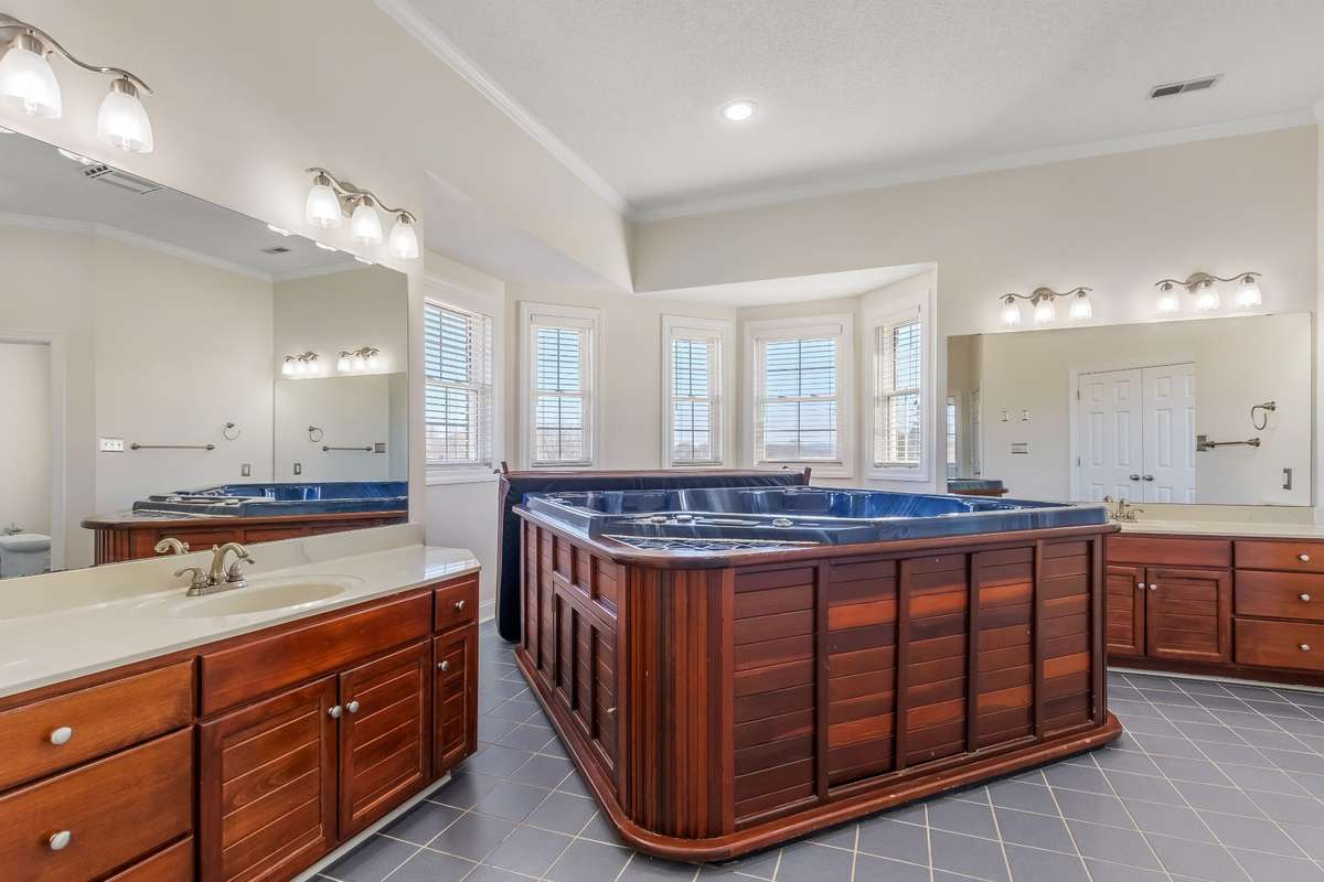 Two complete vanities on either side of your hot tub across from your walk in closet and water closet. There is a separate water heater on this side of the home.