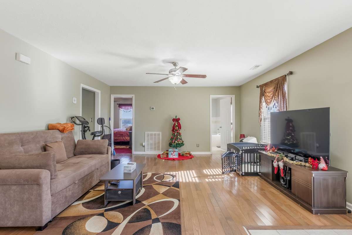 The larger bedroom is located directly in front of us through the door on the left, there is a full bathroom through the door on the right.