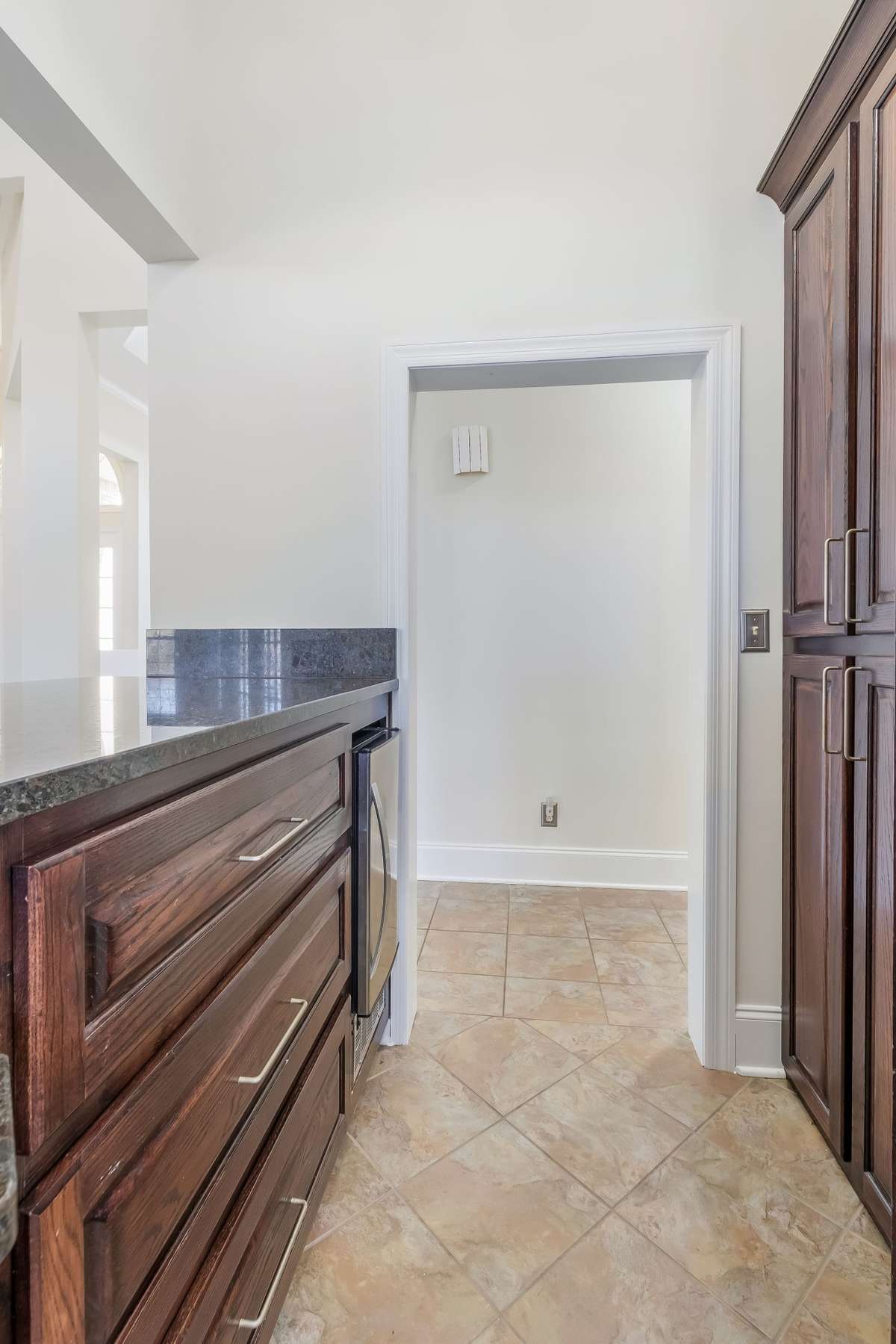 Serving bar located at the back of the kitchen offers deep drawers along with stand up shelving.