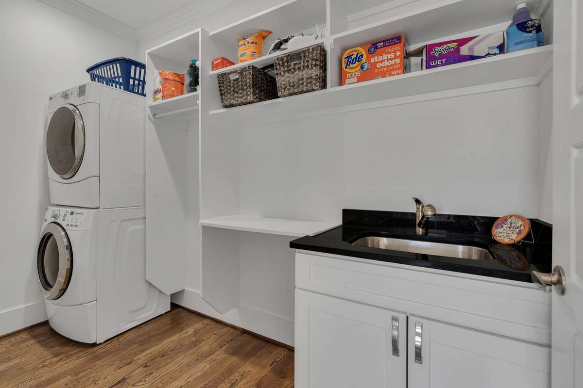 Laundry Room is located upstairs with a sink, folding area and hanging rod. Washer/Dryer convey. Shelves/cabinets have been freshly painted.