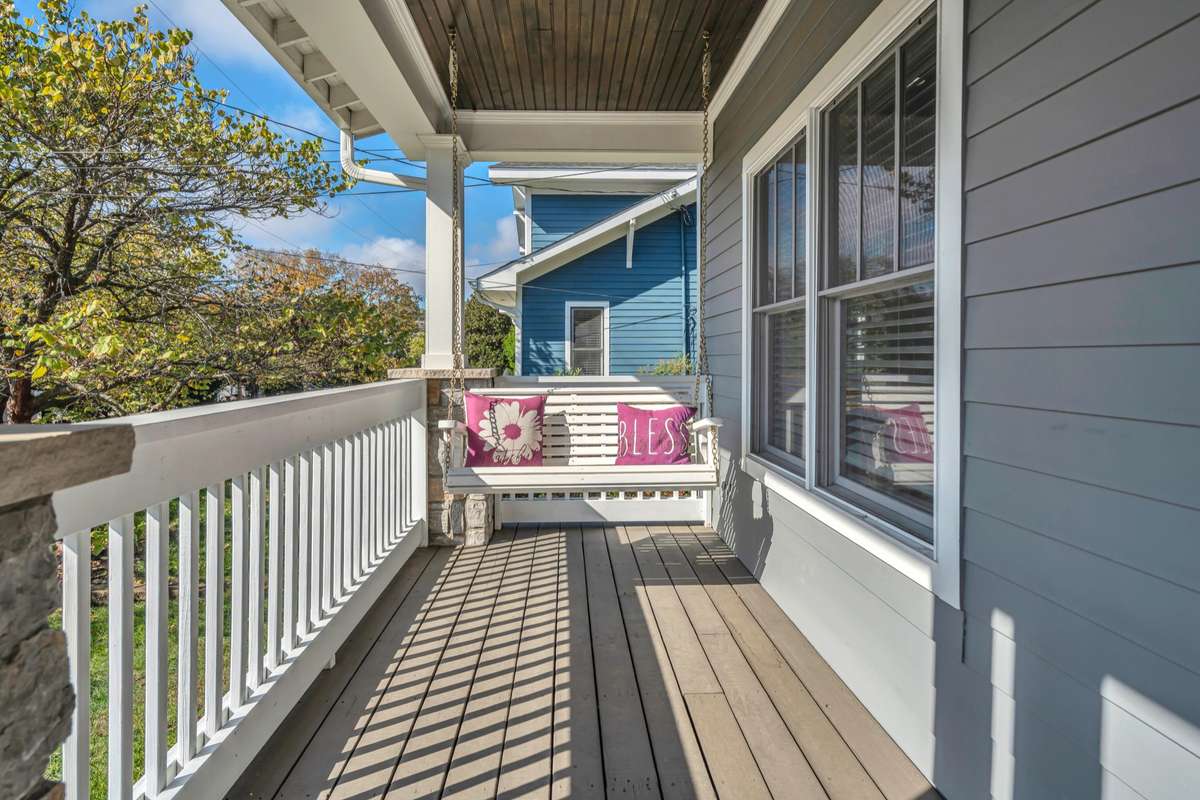 Watch the world on your large front porch with plenty of space for a porch swing and rocking chairs. (swing conveys)