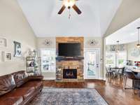 Beautiful stone fireplace is the heartbeat of the living room with these vaulted ceilings.