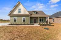 The stained front door and natural-wood wrapped columns add the perfect textures to the front porch!