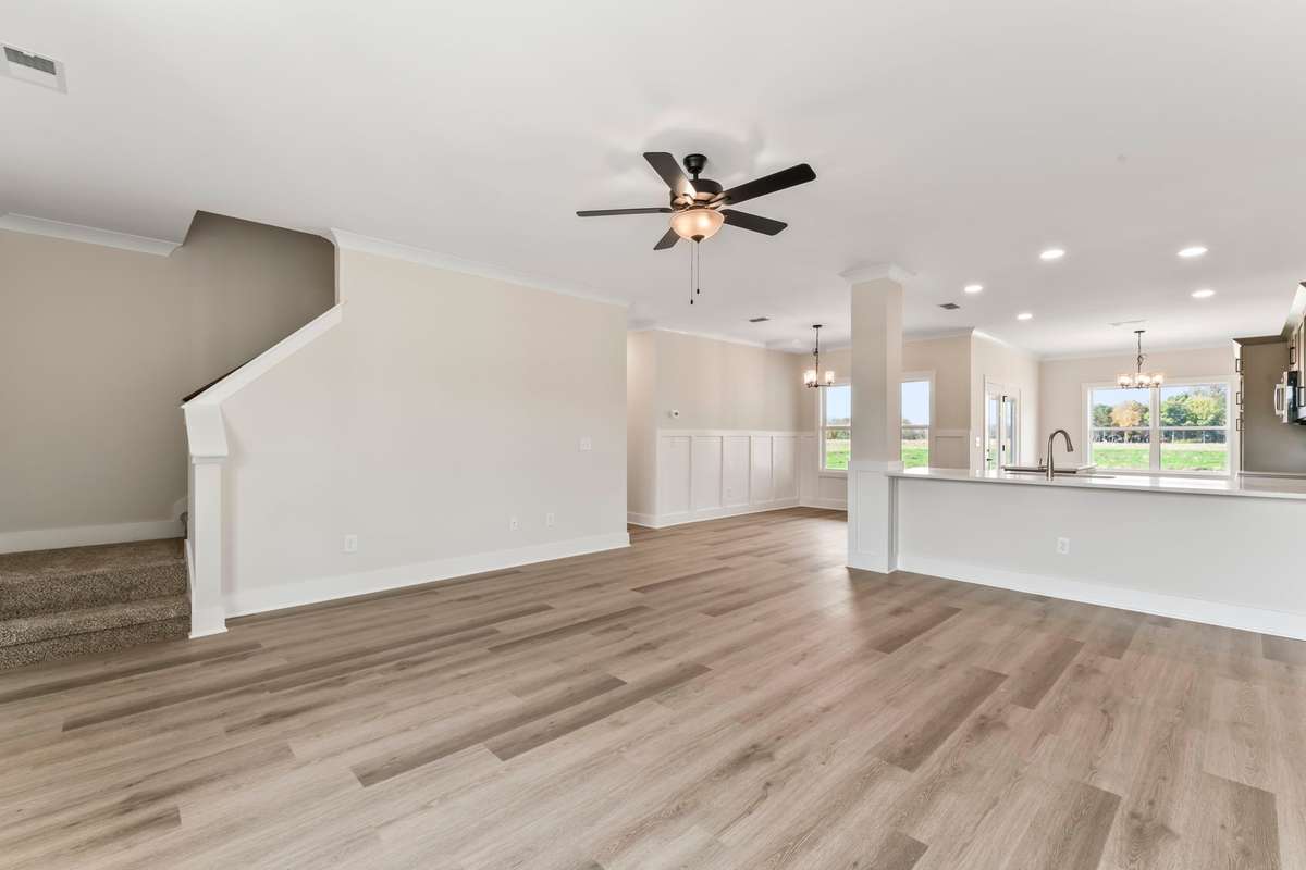The stairs are tucked behind the front door.