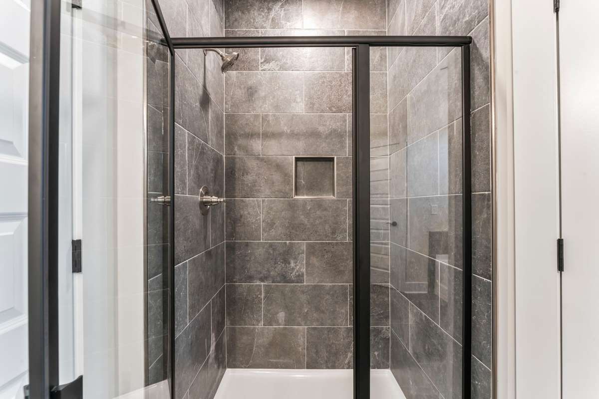 This shower is a dream! The floor to ceiling dark gray tiles continue here. You'll never want to get out!