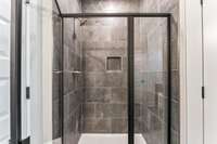 This shower is a dream! The floor to ceiling dark gray tiles continue here. You'll never want to get out!