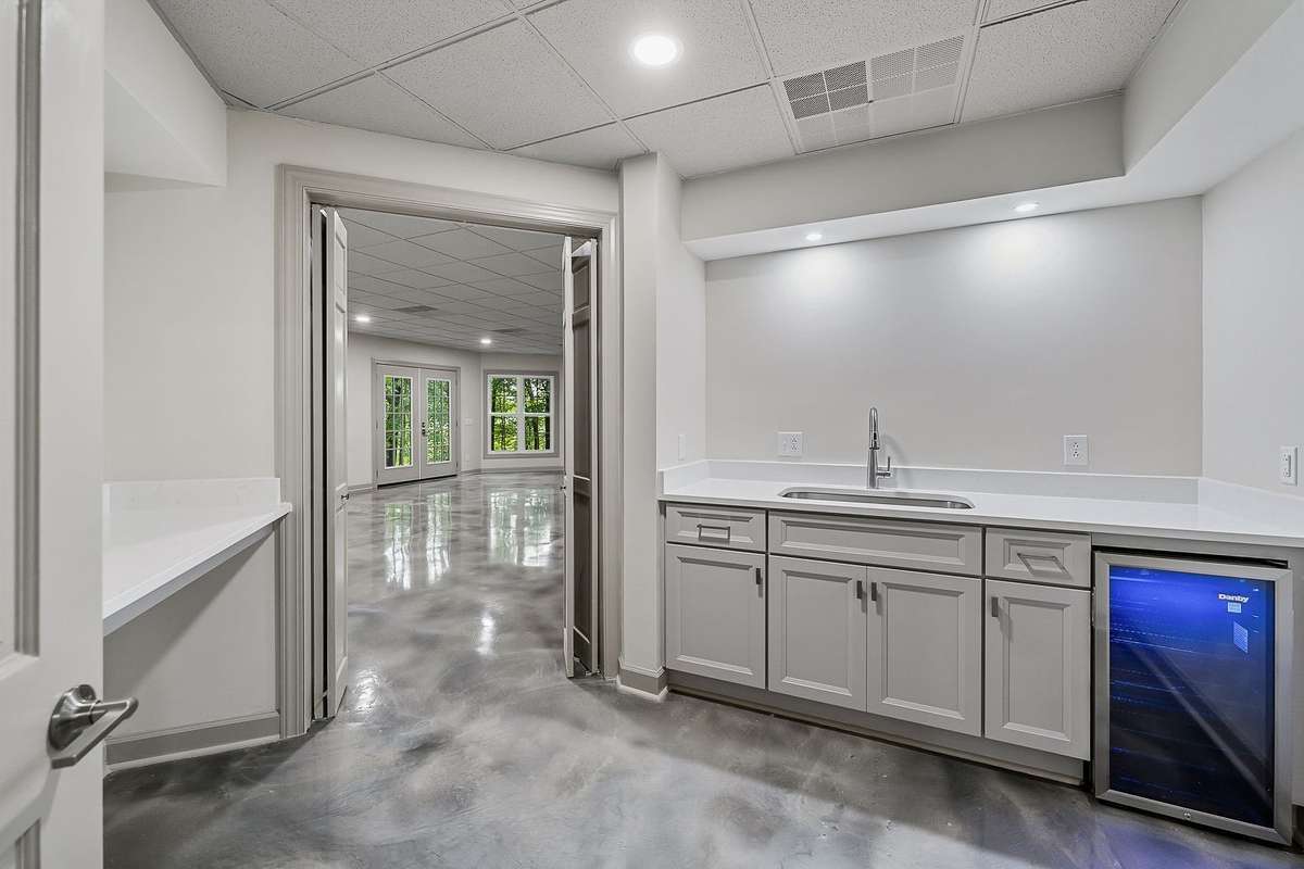 Kitchenette on lower level with counter area, sink and fridge