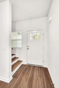 Bright foyer w/rich hardwood flooring, white door w/windows & staircase to left leads to oversized 4th bed w/ensuite or bonus room.