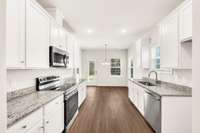 Light-filled dining area extends from the galley kitchen, offering backyard views and easy outdoor access— open feel from prep to patio.