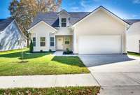 Charming 2-story home with 2-car garage, fresh gray siding, white trim & welcoming front porch. Sunny lot w/mature trees, autumn foliage & manicured lawn.