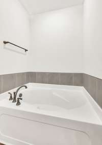 The main bedroom features a stunning bathroom with a generously sized standalone separate shower and oversized soaking tub  both surrounded by tasteful tile accents that add texture and character.