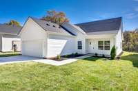 Sleek and inviting, this modern home features crisp white Hardie Board siding, a dark architectural roof, and a spacious two-car garage. The covered entry and clean landscaping create timeless curb appeal with a polished, low-maintenance finish.