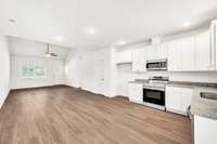 The high, vaulted ceiling in the living area enhances its spacious look as seen from the kitchen area.