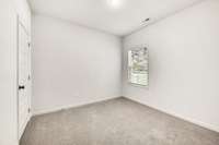 Light-filled bedroom with neutral finishes and soft carpet.