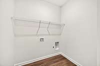 Dedicated laundry room with durable flooring, shelving for storage, and convenient hookups ready for washer and dryer installation.