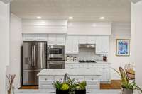 Kitchen features updated white cabinets, gas range and new refrigerator.