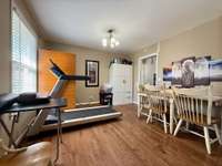 Dining area currently used as a workspace with treadmill and infrared sauna