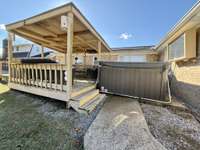 Hot tub and lounge area with TV just around the covered carport