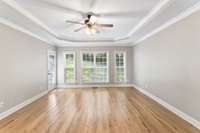 The primary bedrroom has a wall of windows providing natural light and access to the patio.