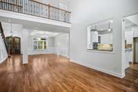 Another angle of the spacious living room highlighting the dramatic ceilings and open balcony above.
