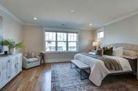 The sun-kissed primary bedroom is generously sized with space for a king-sized bed, two large night stands and a sitting area.