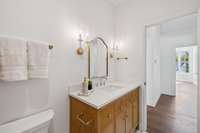 Upstairs bath with reeded vanity positioned off the main hallway