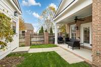 Great fenced in yard off of the living room featuring a covered outdoor living space between the townhome and detached garage