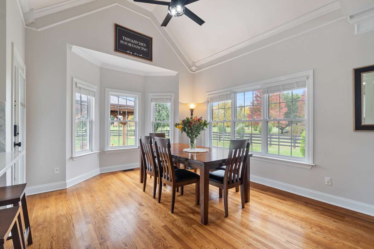 The main dining area in the kitchen has a vaulted ceiling, bay window and glass door leading to the patio.