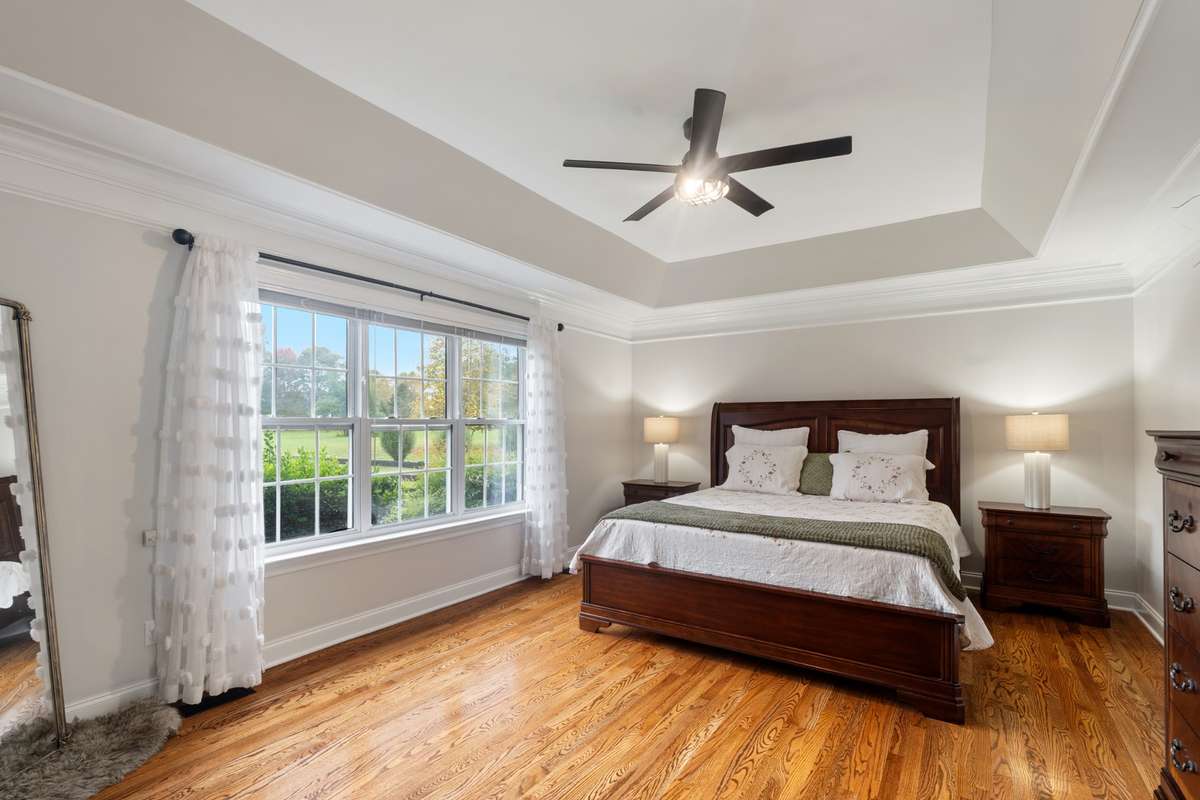 The primary suite is bright and cheerful with a triple window overlooking the backyard.