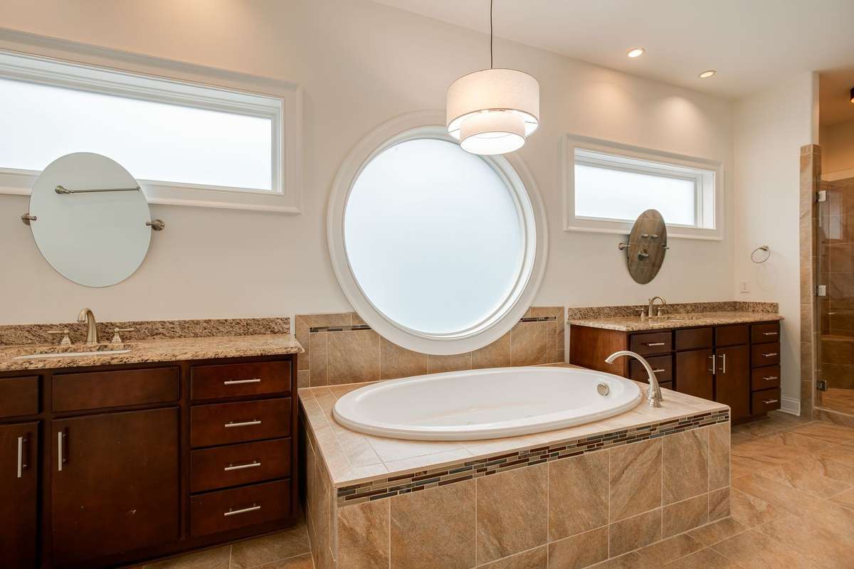 The large Primary Ensuite is a spacious and luxurious bathroom designed as a private spa-like retreat with the jetted bathtub, oversized tile surround shower and the TWO walk-in closets with built in shelves.