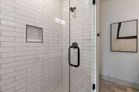 Beautiful subway tiled walk-in shower in the primary bath.