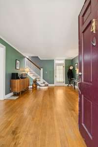 The natural hardwood floors and striking stairway catch your eye as you step through the front door.