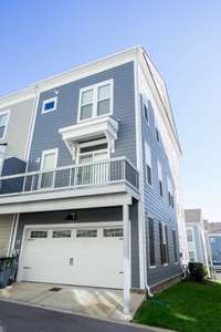 Rear view of townhome with garage and deck