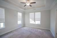 Primary Bedroom - w/ walk in closet, bathroom with large tiled shower, ceiling fan and lots of windows