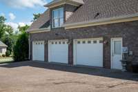 A Three Car Garage, Pedestrian Door and Concreted Driveway